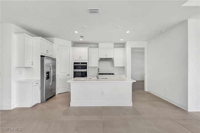 44494 Little Blue Heron Way, Punta Gorda, FL 33982 - kitchen with stainless steel refrigerator with ice dispenser, double wall oven, white cabinetry, light countertops, and an island with sink