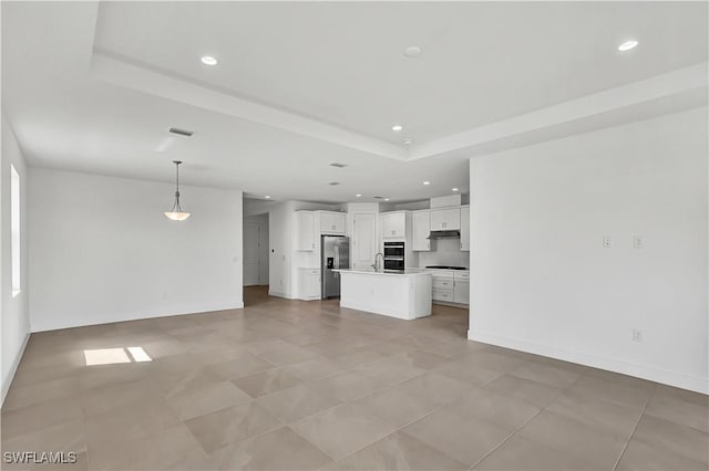 44494 Little Blue Heron Way, Punta Gorda, FL 33982 - unfurnished living room featuring recessed lighting, a tray ceiling, a sink, baseboards, and light tile patterned floors