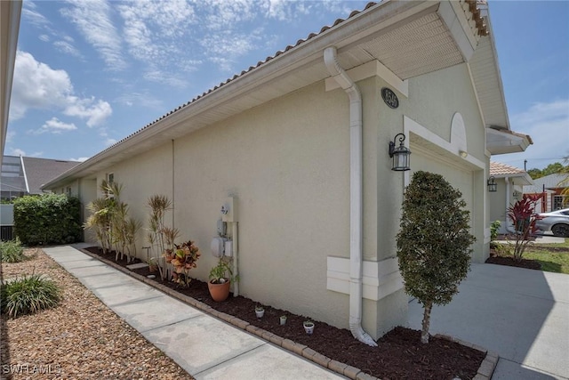 8546 Silk Oak Ln, Naples, FL 34119 - view of side of property featuring stucco siding and a garage