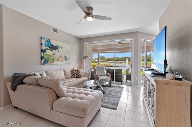 living area with light tile patterned flooring, ceiling fan, and baseboards