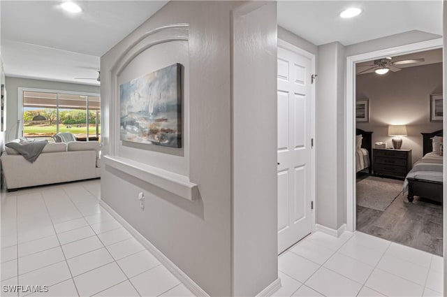 hallway with light tile patterned floors, recessed lighting, and baseboards