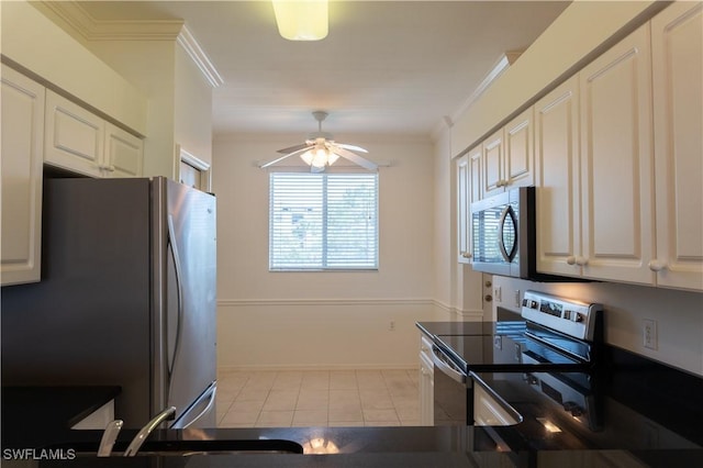kitchen with a ceiling fan, dark countertops, stainless steel appliances, crown molding, and tile patterned flooring