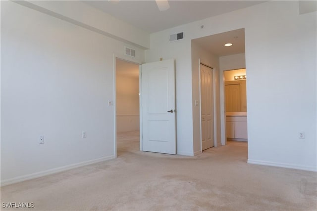 unfurnished bedroom with baseboards, carpet flooring, connected bathroom, and visible vents