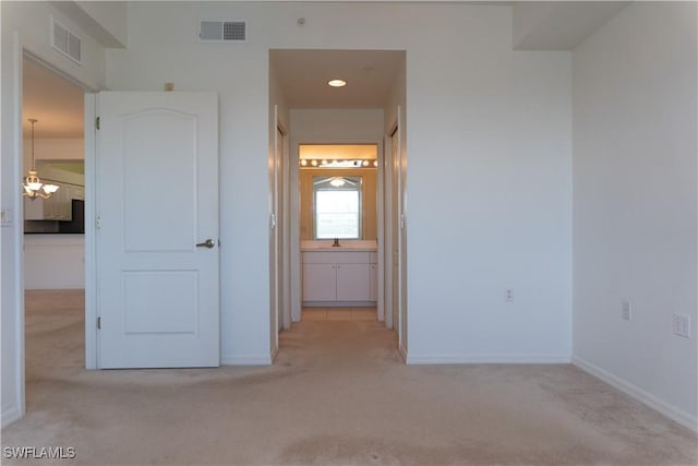 unfurnished bedroom with baseboards, visible vents, and light colored carpet