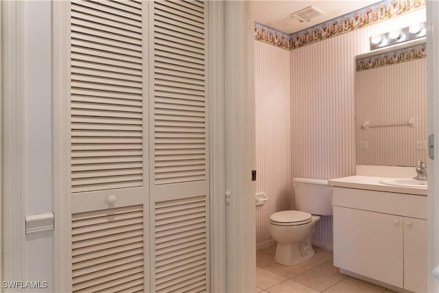 bathroom featuring toilet, tile patterned flooring, a closet, and vanity