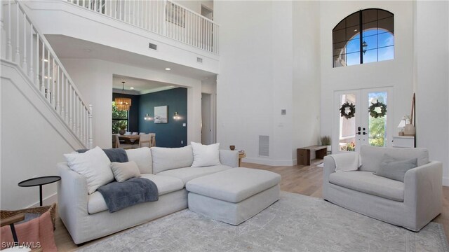 2954 Cinnamon Bay Cir, Naples, FL 34119 - living room with a towering ceiling, a chandelier, stairs, wood finished floors, and baseboards