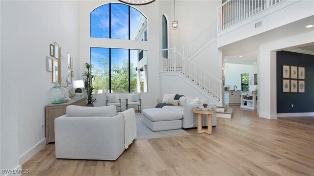 2954 Cinnamon Bay Cir, Naples, FL 34119 - living room with stairs, light wood-type flooring, a towering ceiling, and baseboards