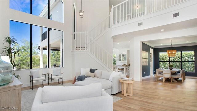 2954 Cinnamon Bay Cir, Naples, FL 34119 - living area with stairway, baseboards, a high ceiling, light wood-style floors, and a chandelier