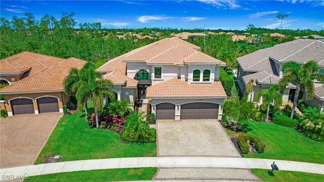 2954 Cinnamon Bay Cir, Naples, FL 34119 - mediterranean / spanish-style home featuring driveway, a tile roof, stucco siding, and a front lawn