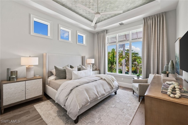 26924 Hickory Blvd, Bonita Springs, FL 34134 - bedroom with a tray ceiling, wood finished floors, and baseboards