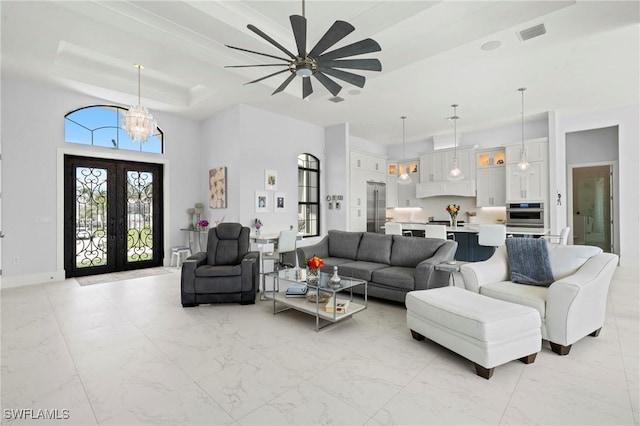 388 Pine Ave, Naples, FL 34108 - living room with a raised ceiling, light marble finish flooring, a chandelier, french doors, and a high ceiling