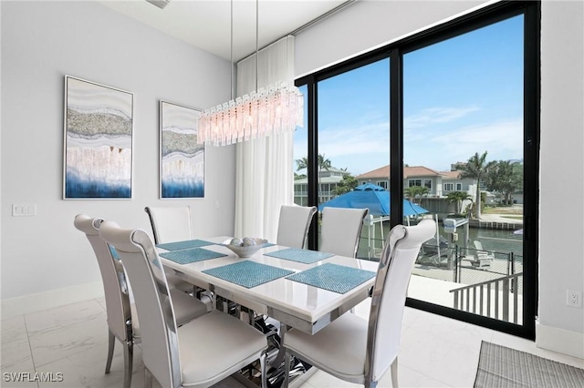 388 Pine Ave, Naples, FL 34108 - dining area with marble look tile flooring, a chandelier, and baseboards