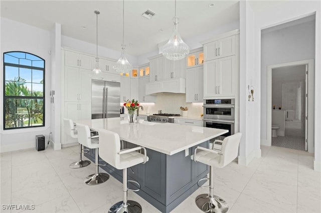 388 Pine Ave, Naples, FL 34108 - kitchen featuring appliances with stainless steel finishes, light marble finish flooring, baseboards, and light countertops