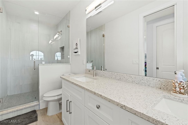 388 Pine Ave, Naples, FL 34108 - full bath featuring double vanity, a stall shower, toilet, and wood finished floors