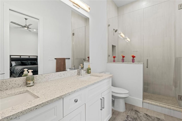 388 Pine Ave, Naples, FL 34108 - ensuite bathroom featuring a shower stall, double vanity, a ceiling fan, wood finished floors, and toilet