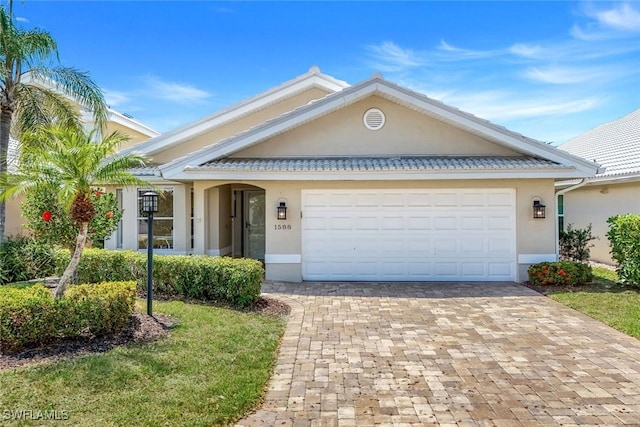 view of front of home with stucco siding, decorative driveway, and an attached garage