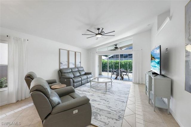 living room with ceiling fan, light tile patterned floors, vaulted ceiling, and baseboards