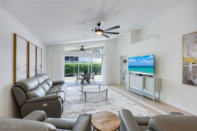 tiled living room featuring vaulted ceiling, a ceiling fan, and baseboards