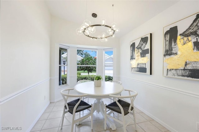 dining room with a chandelier, light tile patterned floors, and baseboards