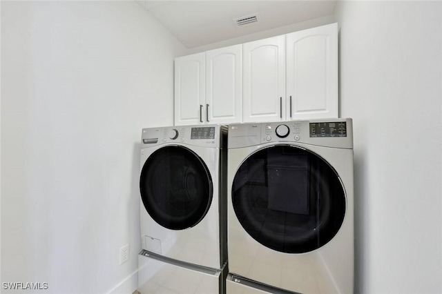 washroom with separate washer and dryer, cabinet space, and baseboards