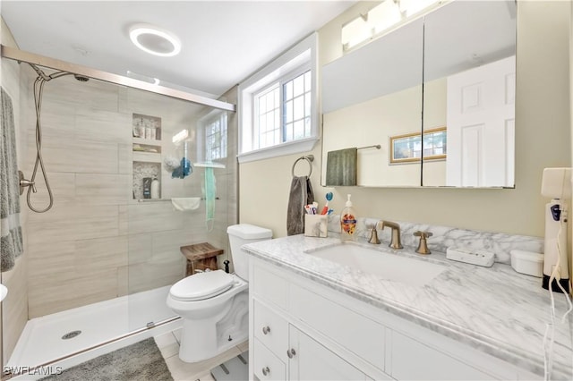 bathroom featuring toilet, a stall shower, and vanity