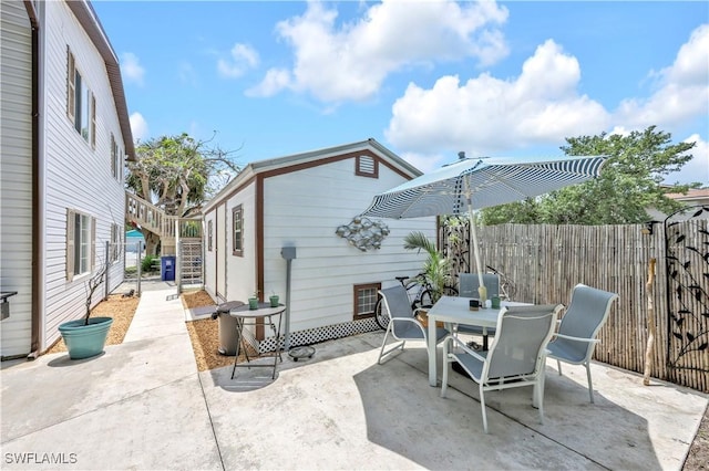 view of patio / terrace with a fenced backyard, outdoor dining space, and stairs