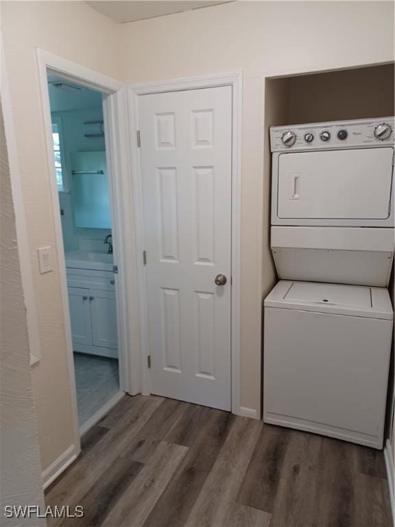 washroom featuring stacked washing machine and dryer and dark wood-type flooring