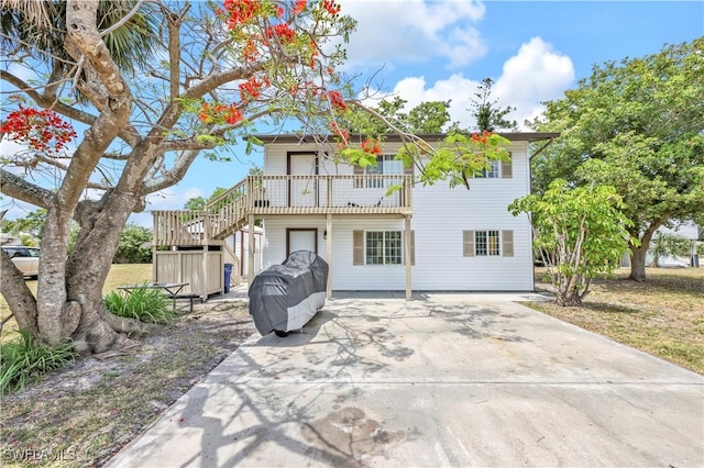 back of house featuring stairway and concrete driveway