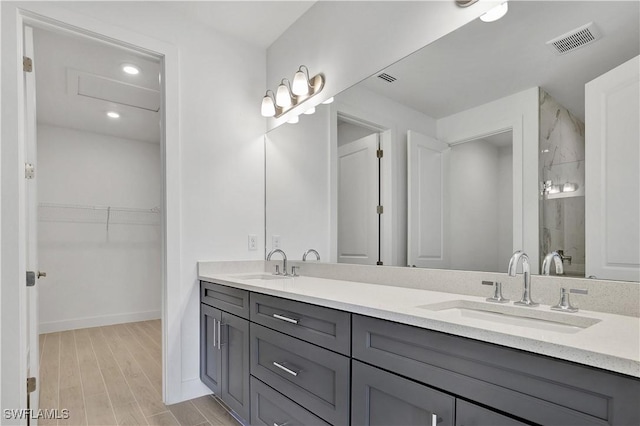 44287 Panther Dr, Punta Gorda, FL 33982 - bathroom featuring double vanity, wood finished floors, a shower, baseboards, and recessed lighting