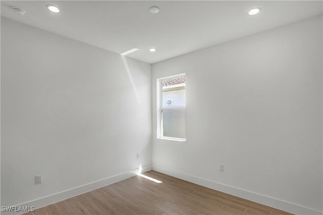 44287 Panther Dr, Punta Gorda, FL 33982 - empty room featuring light wood finished floors, baseboards, recessed lighting, and a smoke detector
