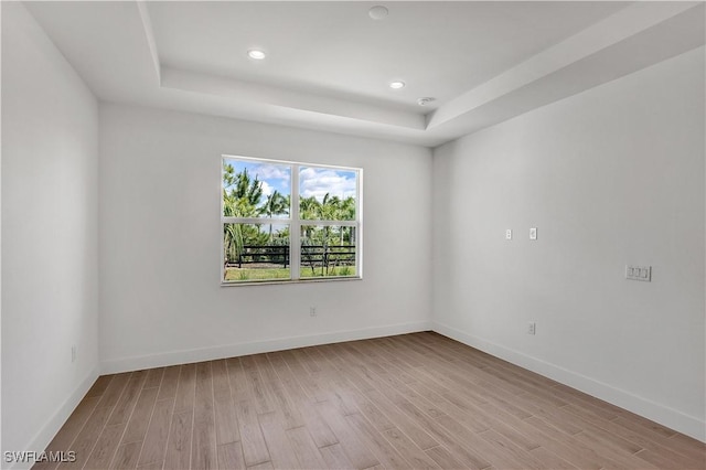 44287 Panther Dr, Punta Gorda, FL 33982 - spare room featuring light wood-type flooring, a tray ceiling, baseboards, and recessed lighting