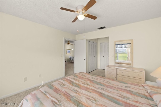 6861 Bogey Dr, Fort Myers, FL 33919 - bedroom with light colored carpet, multiple closets, a textured ceiling, and ceiling fan
