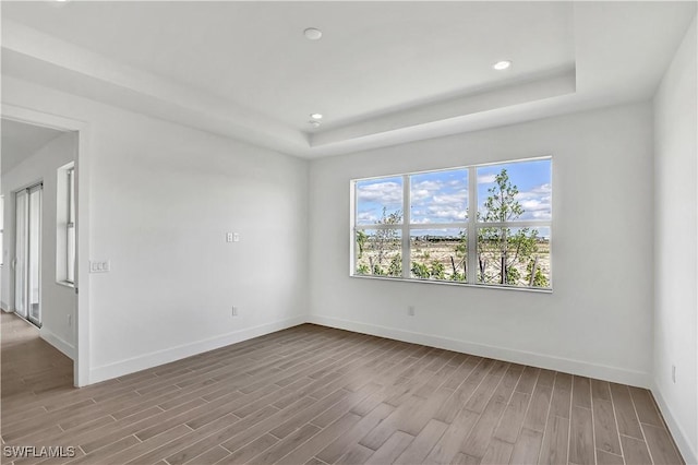 44512 Little Blue Heron Way, Punta Gorda, FL 33982 - empty room with wood finished floors, baseboards, a raised ceiling, and recessed lighting