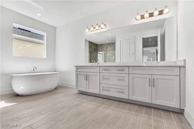 44512 Little Blue Heron Way, Punta Gorda, FL 33982 - bathroom with baseboards, a stall shower, wood finished floors, and double vanity