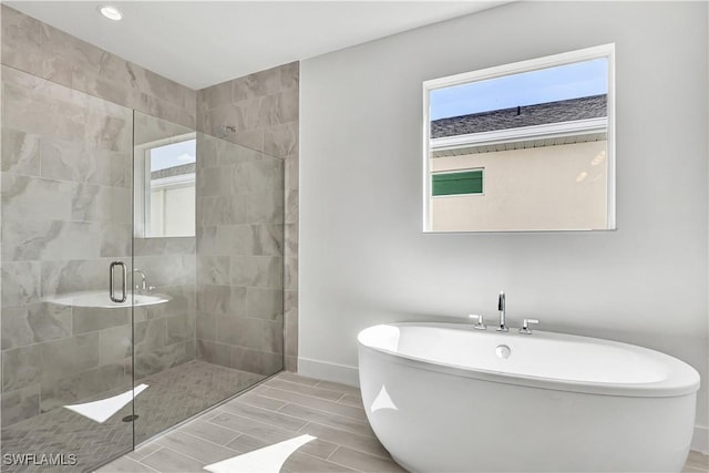 bathroom featuring a shower stall, a freestanding bath, baseboards, recessed lighting, and wood tiled floors