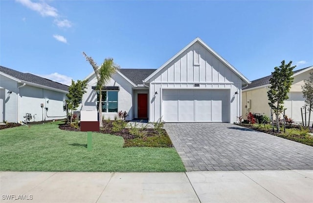 modern inspired farmhouse with board and batten siding, a garage, decorative driveway, and a front lawn