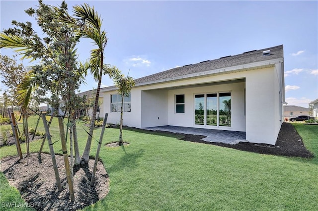 44512 Little Blue Heron Way, Punta Gorda, FL 33982 - back of house with stucco siding, a patio, and a lawn