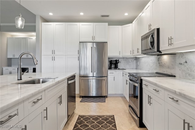 9380 Triana Ter Unit 312, Fort Myers, FL 33912 - kitchen with stainless steel appliances, a sink, white cabinetry, decorative backsplash, and light stone counters