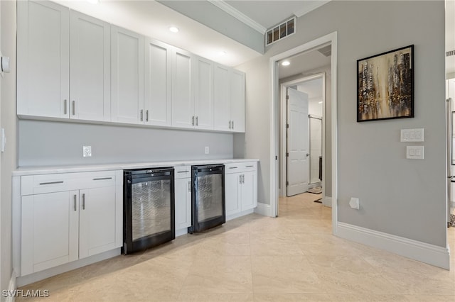 9380 Triana Ter Unit 312, Fort Myers, FL 33912 - kitchen featuring wine cooler, ornamental molding, light countertops, baseboards, and white cabinets