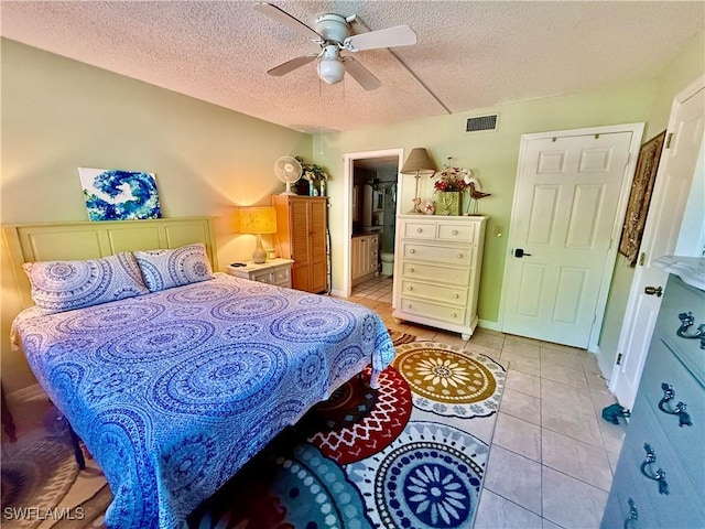 3706 Broadway Unit 18, Fort Myers, FL 33901 - bedroom with light tile patterned floors, a textured ceiling, a ceiling fan, and ensuite bathroom