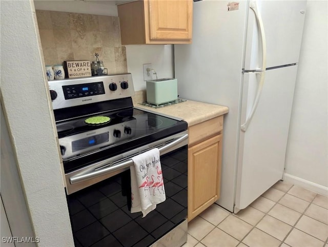3706 Broadway Unit 18, Fort Myers, FL 33901 - kitchen featuring electric stove, light brown cabinetry, freestanding refrigerator, light countertops, and light tile patterned floors