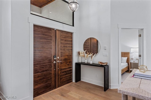 foyer with light wood-style flooring and baseboards