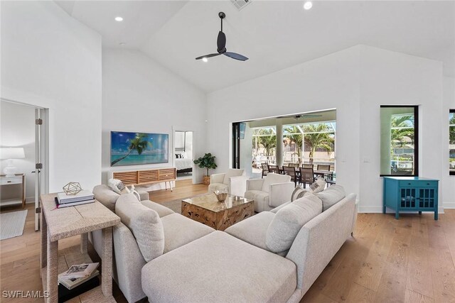living room with high vaulted ceiling, a ceiling fan, light wood-type flooring, and recessed lighting