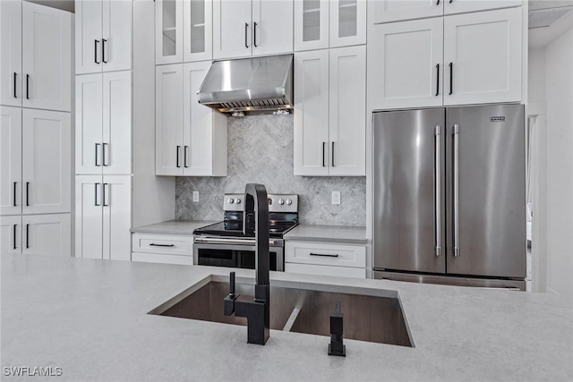 kitchen with stainless steel appliances, under cabinet range hood, light countertops, and white cabinets