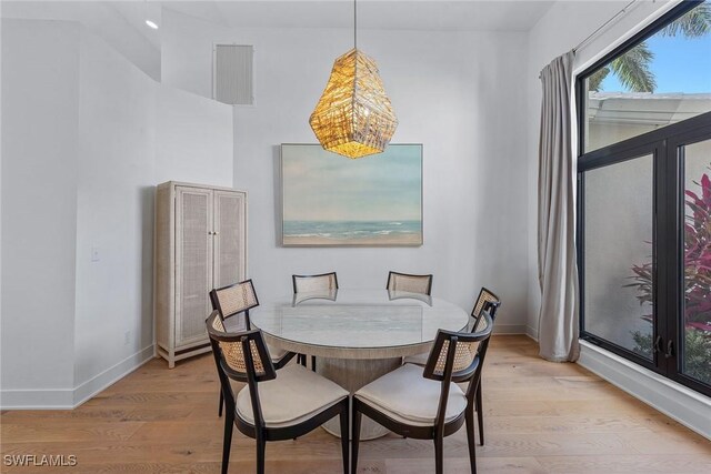 dining room featuring light wood finished floors, baseboards, and a chandelier