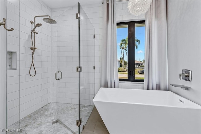 full bathroom featuring a shower stall and a soaking tub