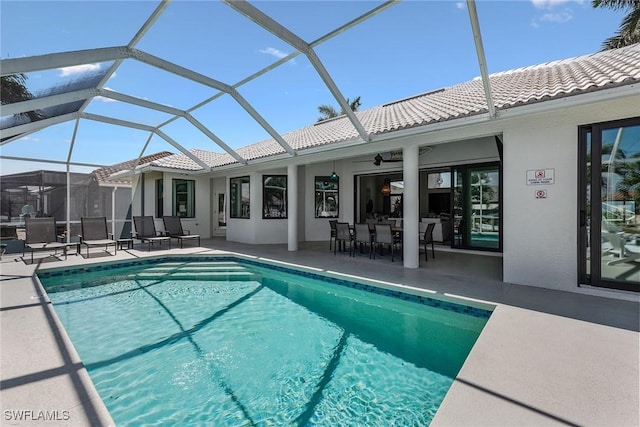 back of property featuring a tile roof, stucco siding, a patio area, an outdoor pool, and a lanai