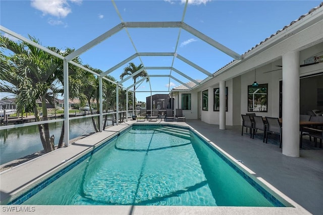 outdoor pool featuring a patio, a water view, and a lanai