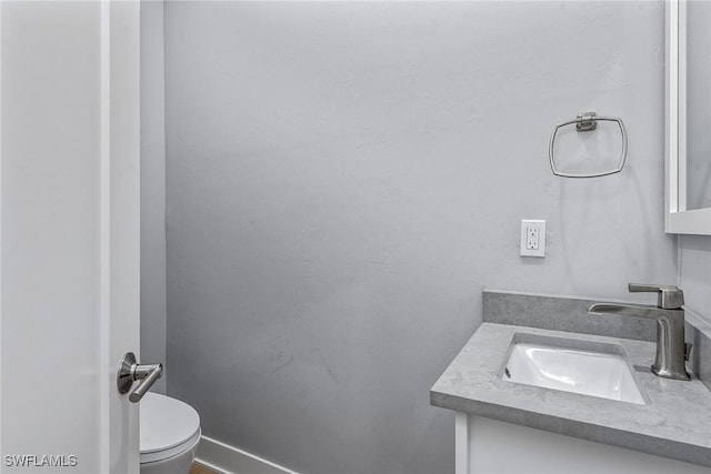 half bath featuring toilet and vanity
