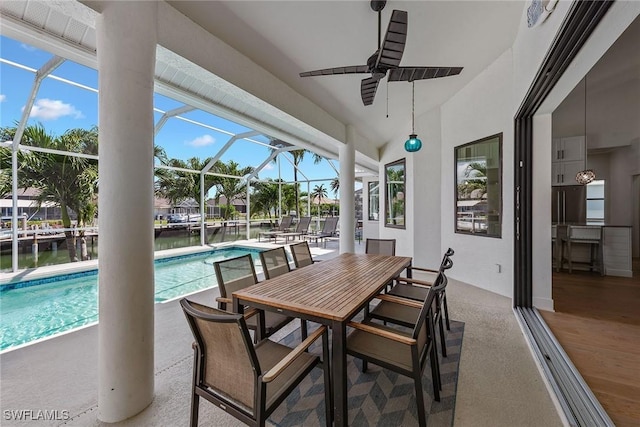 outdoor pool featuring ceiling fan, a lanai, a patio, and a water view